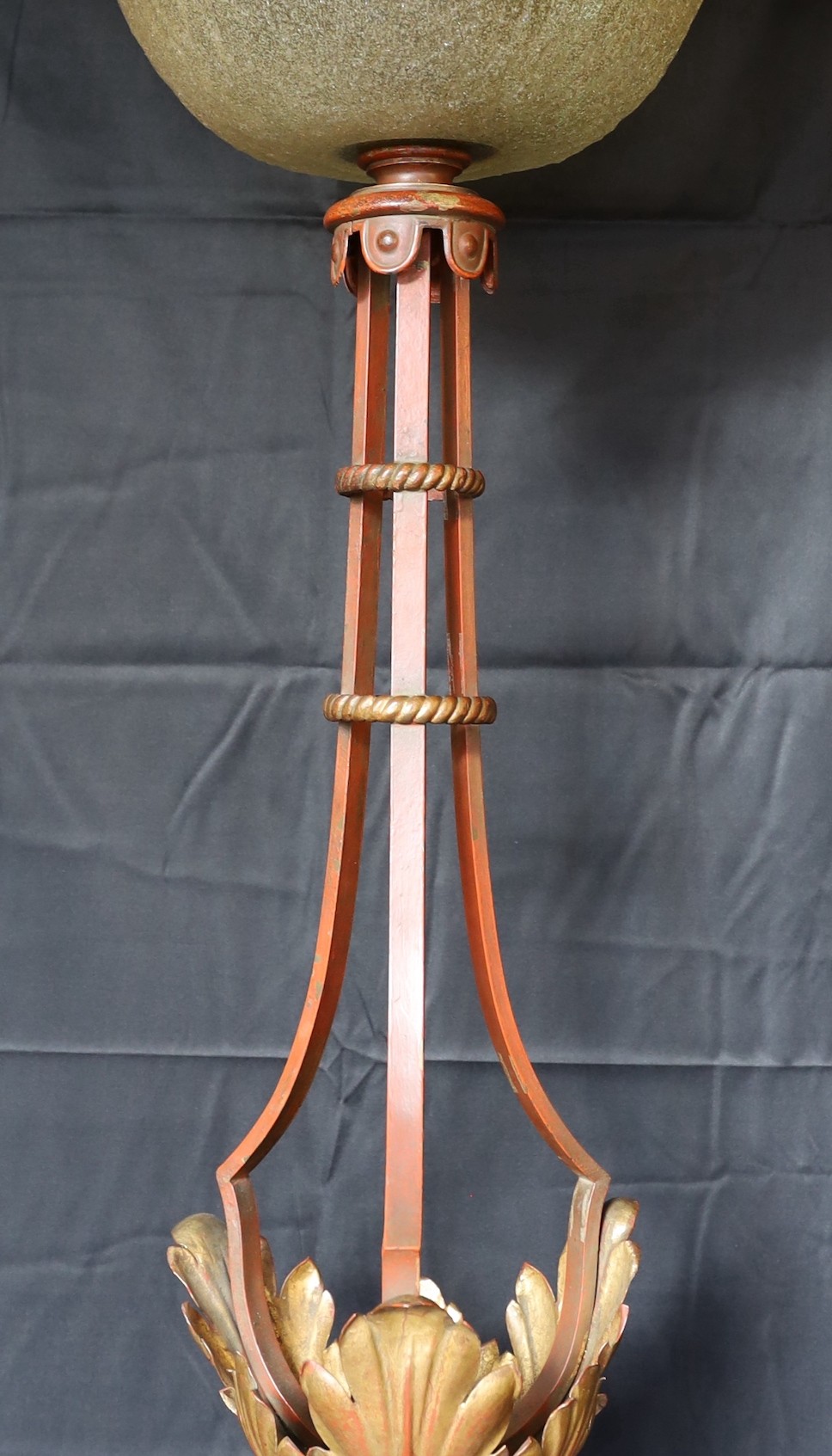 A 1950s Italian parcel gilt red painted wrought iron and tole ware lamp standard with smoked crackle glass shade, height 163cm. diameter 52cm.